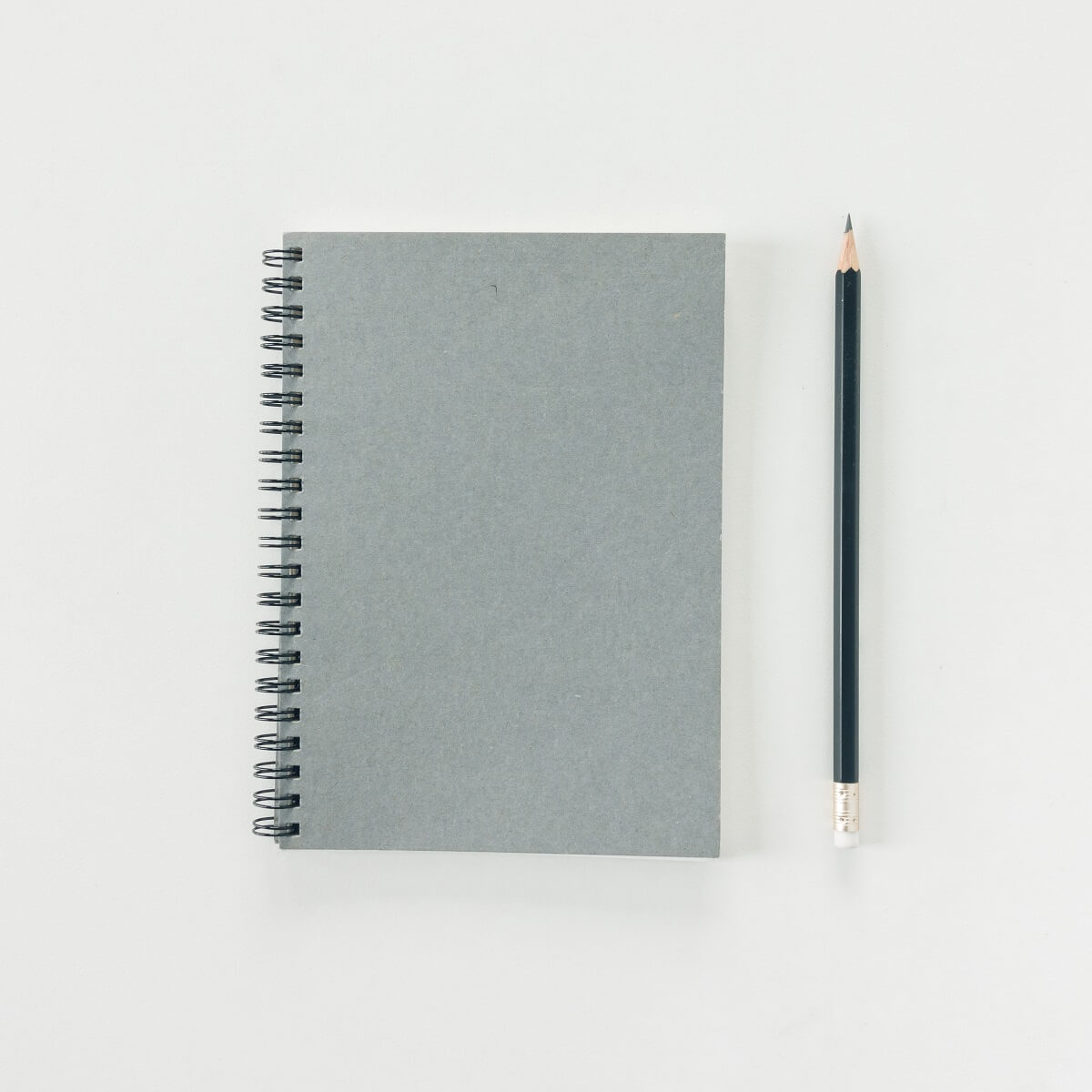 新品のグレーのノートと鉛筆。